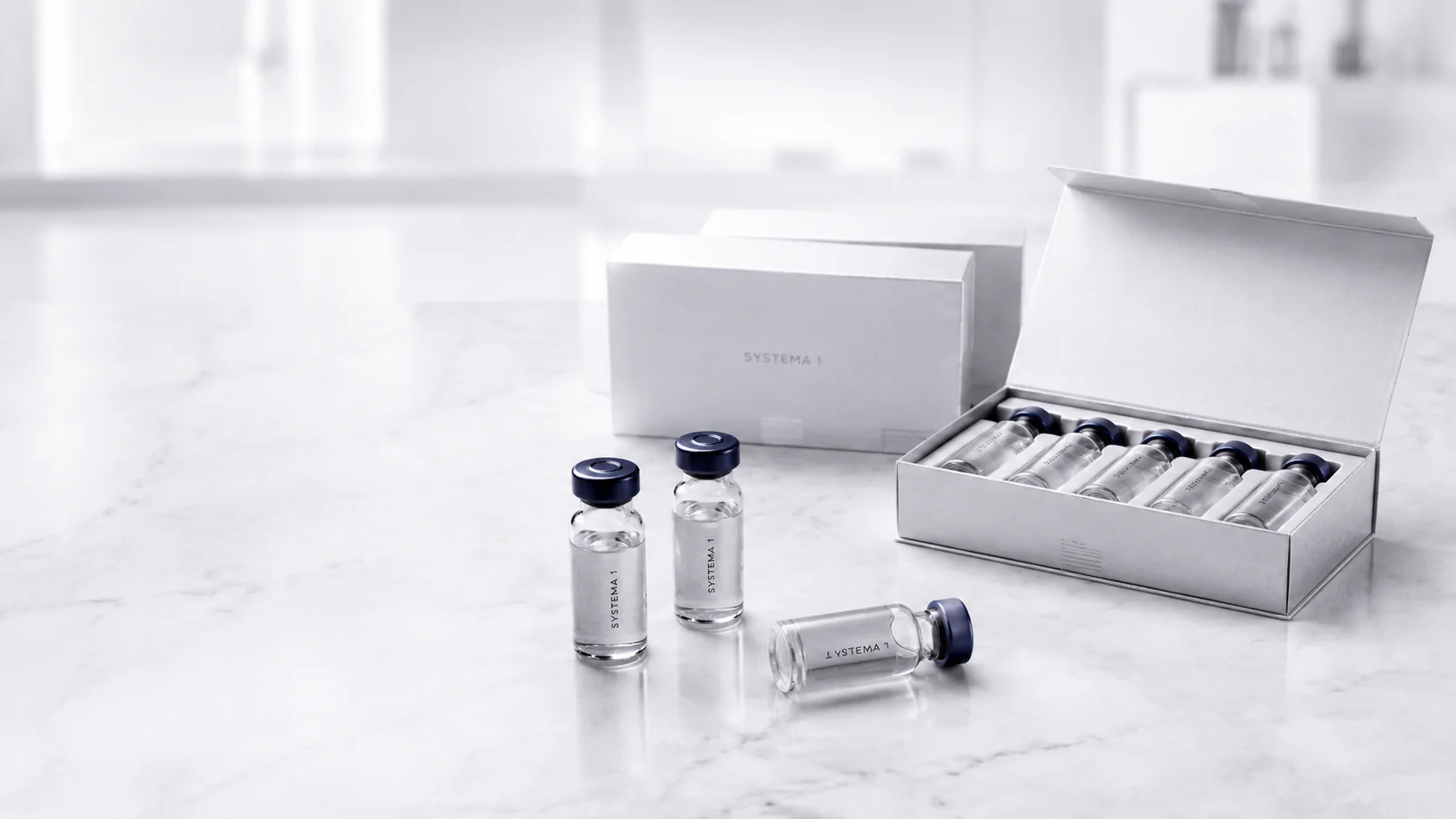 Systema One vials and an open presentation case arranged on a white marble surface